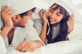 Happy young couple relaxing in the home bedroom.
